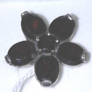 Anillo de plata. Flor con 5 pétalos de granate de 5mm x 8mm y central de 4mm. Diámetro 16mm.